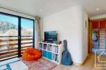 Discover this charming property featuring a cozy living space with a vibrant orange beanbag and a stylish bookshelf.
