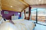Discover the charm of this stunning bedroom, featuring a cozy bed and a beautiful view.