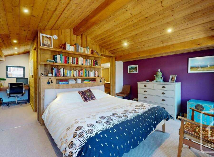 This stunning bedroom boasts a unique wooden ceiling and walls, creating a warm and inviting atmosphere.