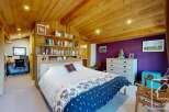 This stunning bedroom boasts a unique wooden ceiling and walls, creating a warm and inviting atmosphere.