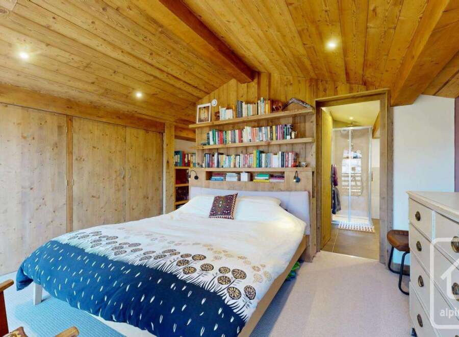 Discover the charm of this cozy bedroom, featuring a stunning wooden ceiling and built-in storage.