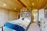 Discover the charm of this cozy bedroom, featuring a stunning wooden ceiling and built-in storage.