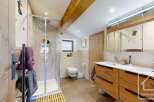 Discover the charm of this beautifully designed bathroom, featuring a modern glass shower and stylish wooden accents.