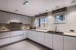 Modern kitchen with white cabinets and sleek countertops.