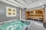 Indulge in ultimate relaxation with this stunning home spa featuring a luxurious jacuzzi and a modern sauna.