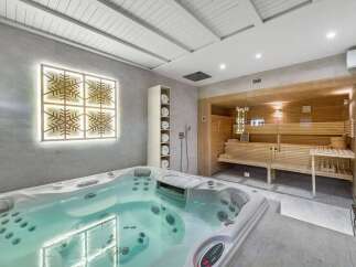 Indulge in ultimate relaxation with this stunning home spa featuring a luxurious jacuzzi and a modern sauna.