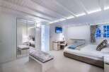 Luxurious bedroom with built-in wardrobe and bench seating.