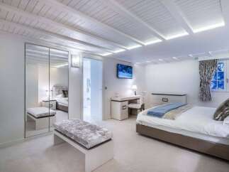 Luxurious bedroom with built-in wardrobe and bench seating.