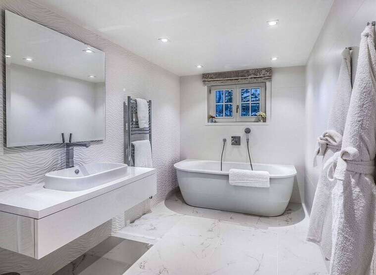 Luxurious bathroom with a freestanding bathtub, modern sink, and heated towel rack.