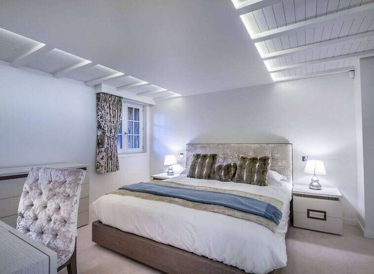Luxurious bedroom with a plush velvet headboard and soft bedding.