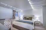 Luxurious bedroom with a plush velvet headboard and soft bedding.