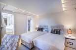 Luxurious twin bedroom with plush velvet headboards and crisp white linens.
