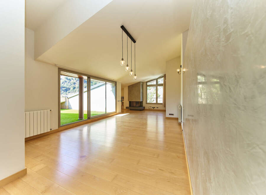 Stunning open-plan living space with hardwood floors and large windows offering scenic views.
