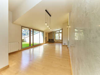 Stunning open-plan living space with hardwood floors and large windows offering scenic views.