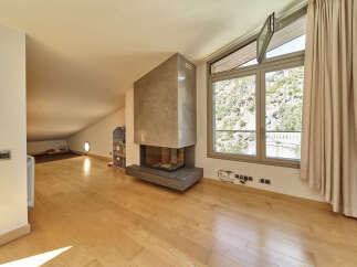 This stunning attic conversion boasts a spacious open-plan living area with gleaming hardwood floors and a modern fireplace as a centerpiece.