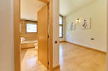 This stunning property boasts a spacious bedroom with light hardwood floors and two elegant ballerina-themed wall art pieces.