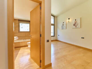 This stunning property boasts a spacious bedroom with light hardwood floors and two elegant ballerina-themed wall art pieces.