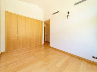 This stunning property boasts a spacious bedroom with gleaming hardwood floors and built-in wooden wardrobes, offering ample storage.