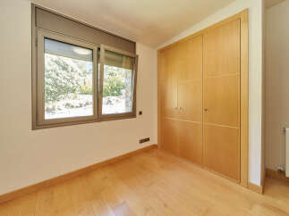 This bright and airy bedroom boasts beautiful hardwood floors and large built-in closets, providing ample storage space.