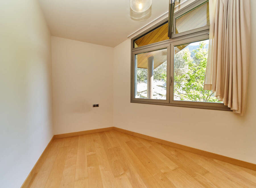 This bright and airy room features beautiful hardwood floors and large windows offering stunning views of the surrounding landscape.