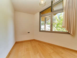 This bright and airy room features beautiful hardwood floors and large windows offering stunning views of the surrounding landscape.
