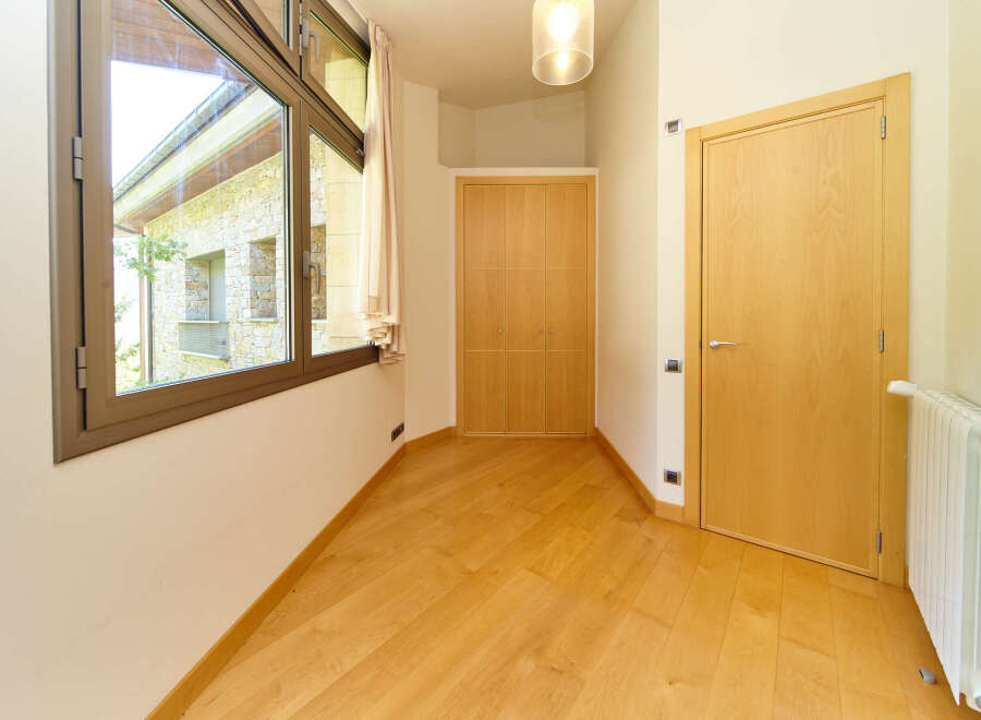 This bright and airy room boasts stunning views through a large window, complemented by light hardwood floors.