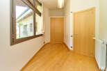This bright and airy room boasts stunning views through a large window, complemented by light hardwood floors.