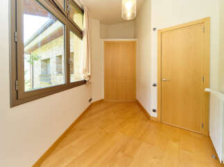 This bright and airy room boasts stunning views through a large window, complemented by light hardwood floors.