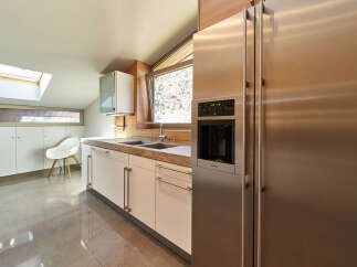 This stunning kitchen boasts modern cabinetry, sleek stainless steel appliances, and a spacious layout.