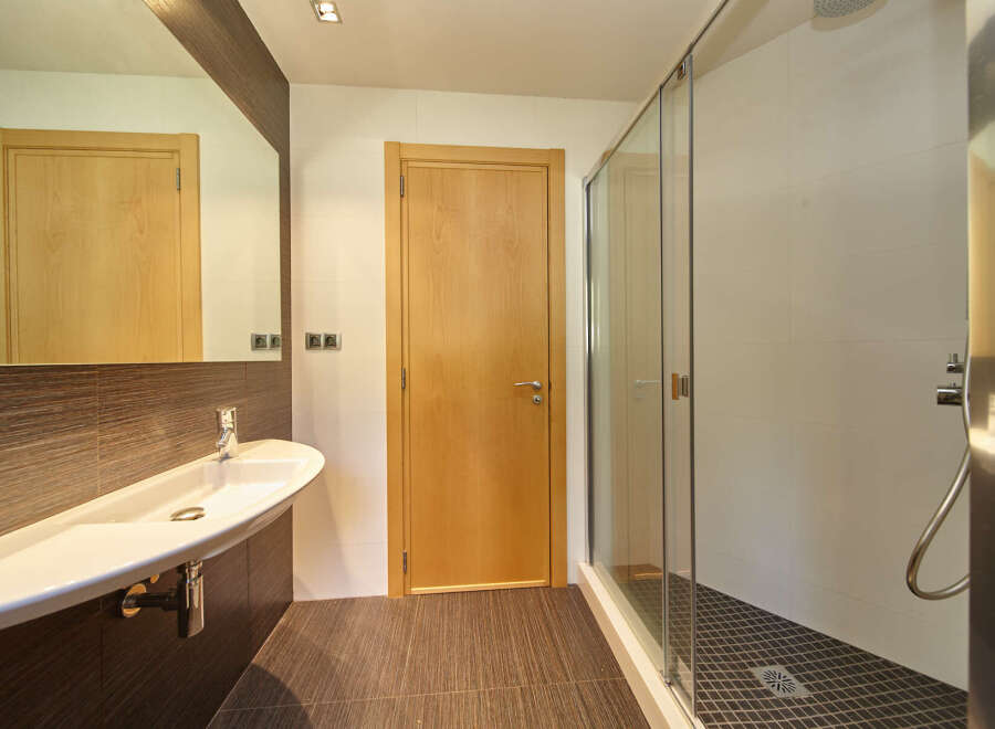 Modern bathroom with a sleek, white sink and a spacious walk-in shower.