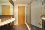 Modern bathroom with a sleek, white sink and a spacious walk-in shower.