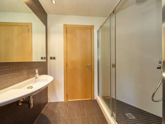 Modern bathroom with a sleek, white sink and a spacious walk-in shower.
