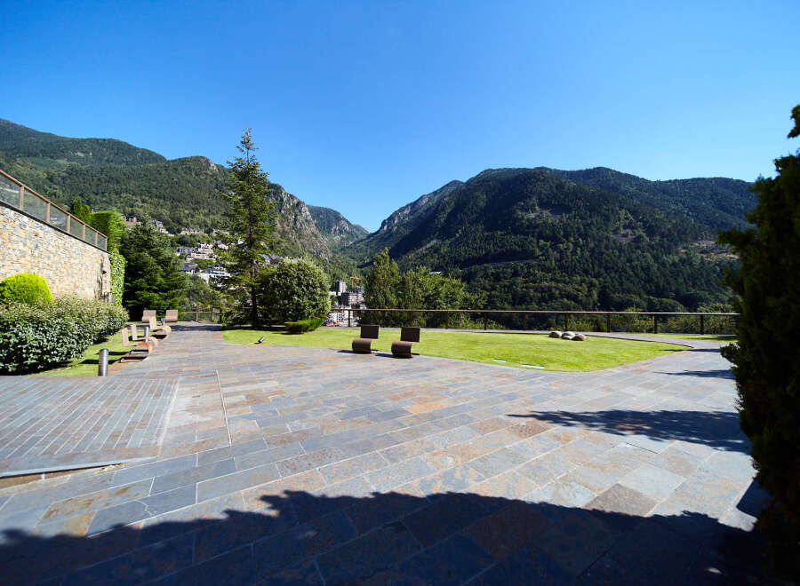 This stunning property boasts a spacious patio with modern seating, offering breathtaking views of the Pyrenees Mountains.