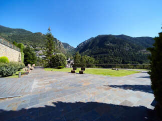This stunning property boasts a spacious patio with modern seating, offering breathtaking views of the Pyrenees Mountains.