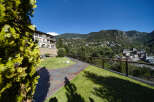 This stunning property boasts a beautifully landscaped garden with a paved pathway, offering breathtaking views of the surrounding mountains.