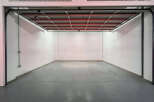Spacious garage with high ceilings and ample floor space, perfect for parking and storage.