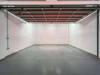 Spacious garage with high ceilings and ample floor space, perfect for parking and storage.