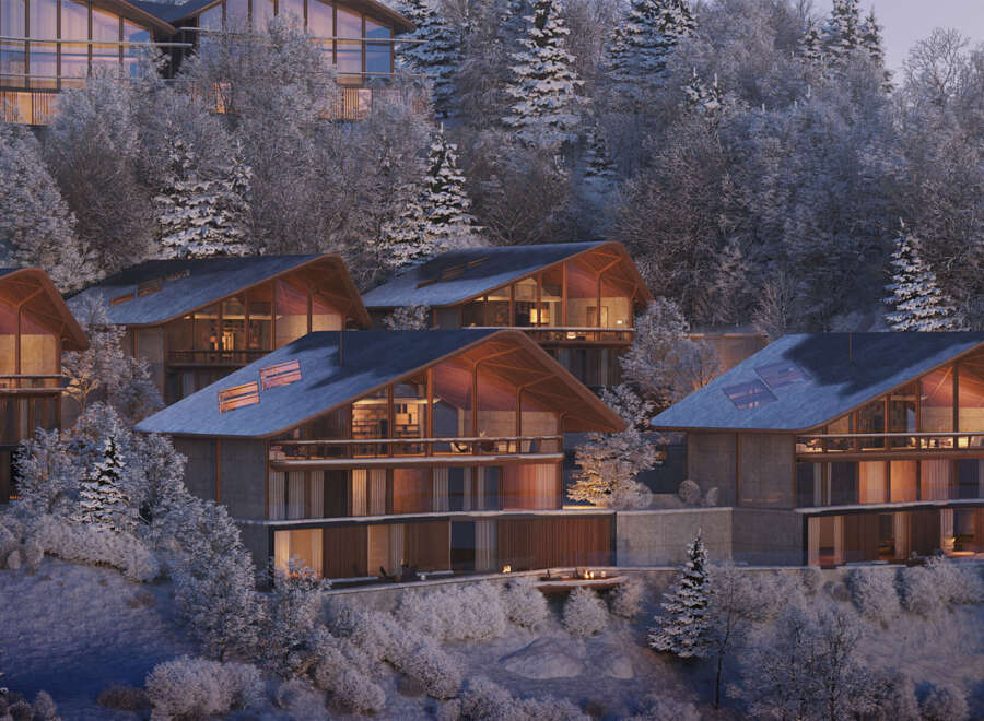 Luxury mountain homes nestled in a snowy forest.