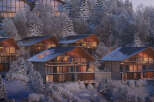 Luxury mountain homes nestled in a snowy forest.