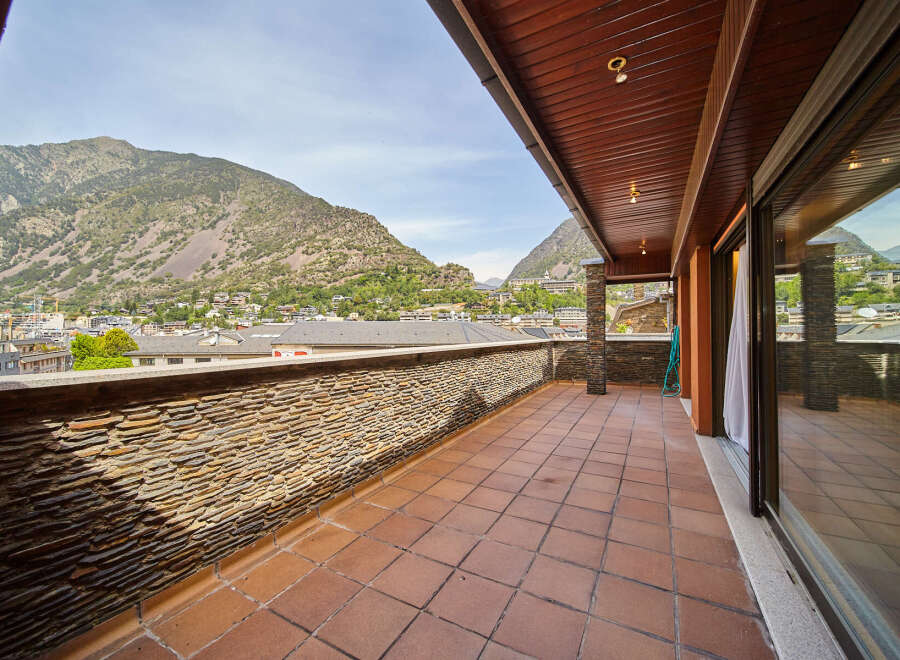 This stunning penthouse boasts a spacious terrace with breathtaking mountain views.