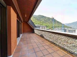 This stunning penthouse boasts a spacious terrace with breathtaking mountain views.