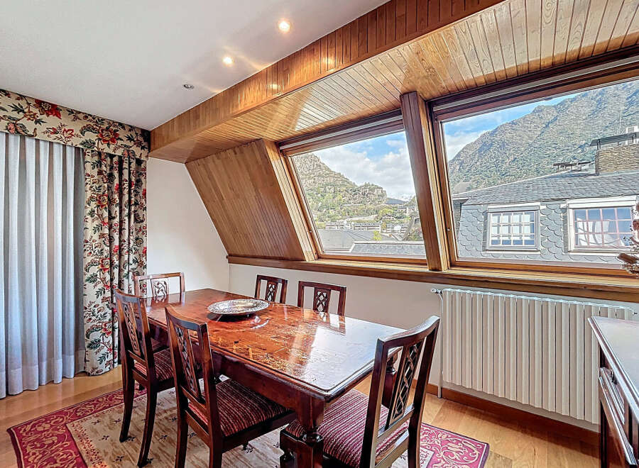 This stunning dining room boasts a breathtaking mountain view through its unique angled windows.