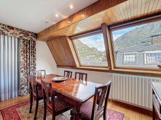 This stunning dining room boasts a breathtaking mountain view through its unique angled windows.