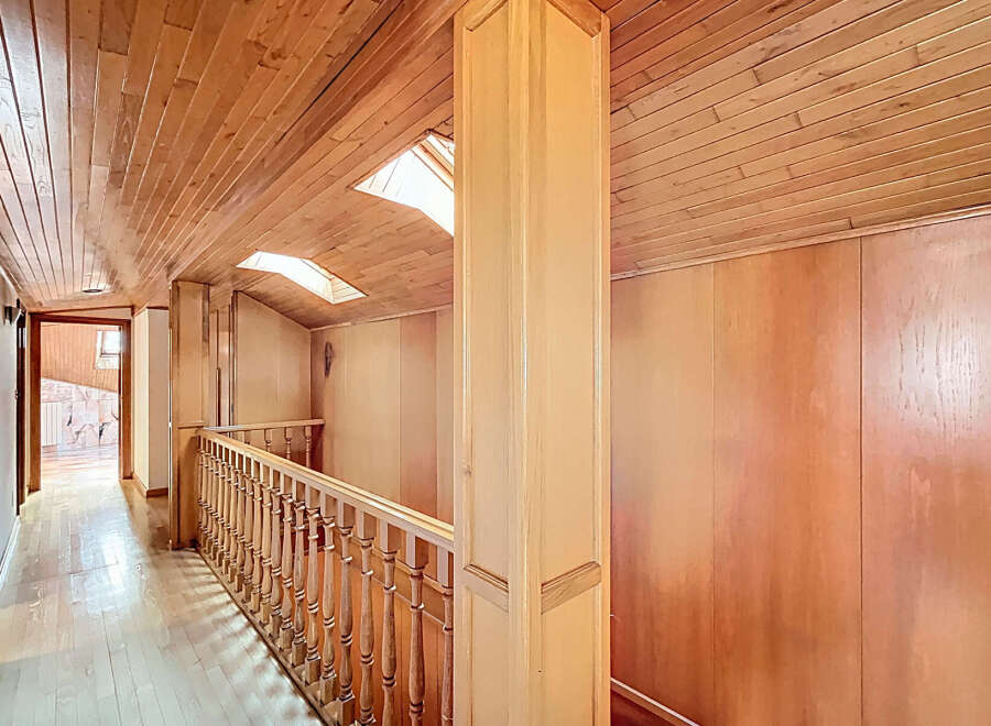 This stunning hallway boasts a beautiful wood-paneled ceiling and walls, creating a warm and inviting atmosphere.