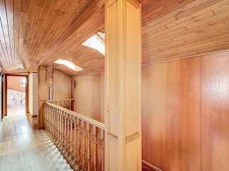 This stunning hallway boasts a beautiful wood-paneled ceiling and walls, creating a warm and inviting atmosphere.