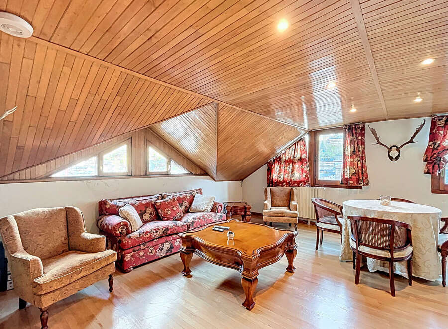 Charming attic apartment with wood-paneled ceilings and hardwood floors.