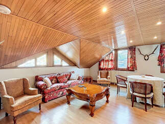 Charming attic apartment with wood-paneled ceilings and hardwood floors.