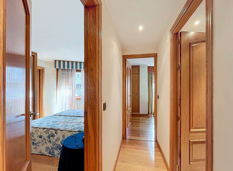 This stunning property boasts a spacious hallway with elegant wooden doors and flooring.