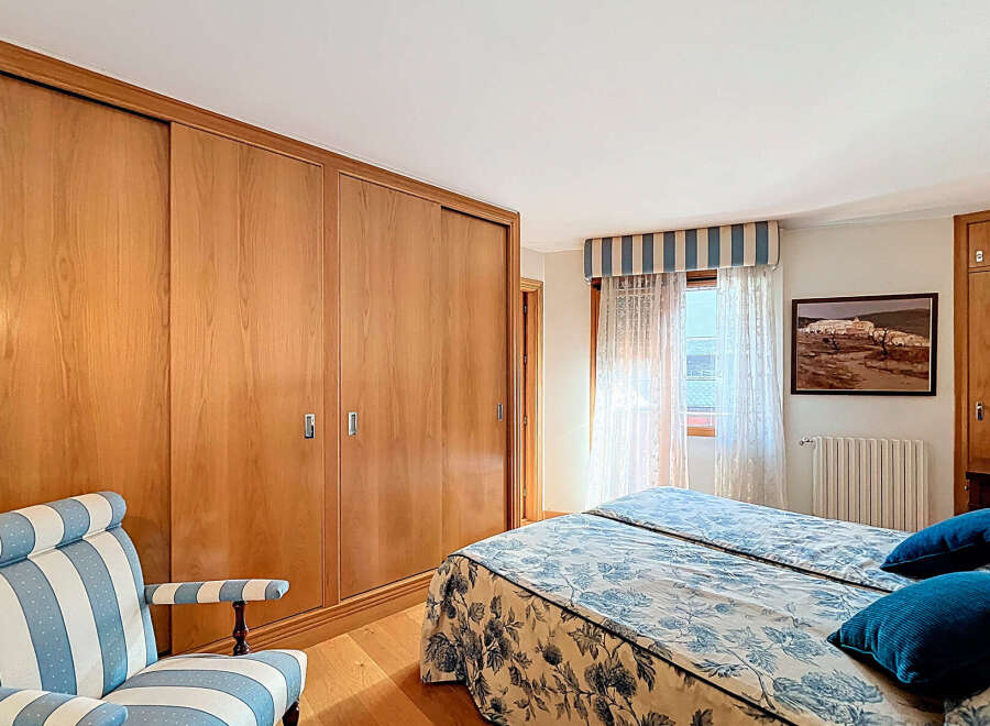 This bedroom boasts built-in wooden wardrobes with sliding doors, offering ample storage space.