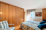 This bedroom boasts built-in wooden wardrobes with sliding doors, offering ample storage space.